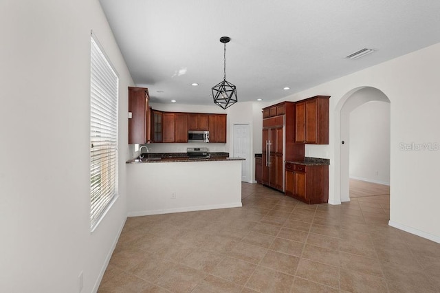 4429 67th St E, Bradenton, FL 34203 - kitchen featuring stainless steel appliances, dark countertops, arched walkways, a sink, and glass insert cabinets