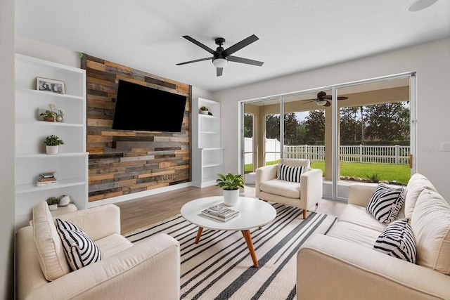 4429 67th St E, Bradenton, FL 34203 - living room featuring a ceiling fan, built in features, wood finished floors, and baseboards