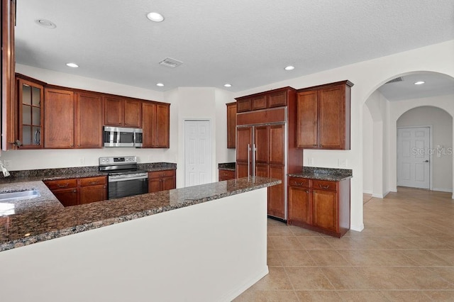 4429 67th St E, Bradenton, FL 34203 - kitchen featuring appliances with stainless steel finishes, a sink, recessed lighting, arched walkways, and light tile patterned floors
