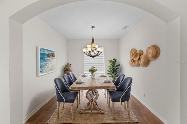 4429 67th St E, Bradenton, FL 34203 - dining room featuring arched walkways, a chandelier, dark wood-style flooring, and baseboards