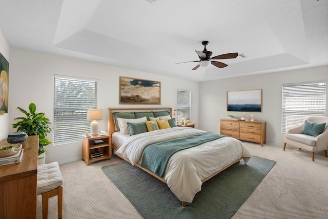 4429 67th St E, Bradenton, FL 34203 - bedroom featuring a tray ceiling, light carpet, multiple windows, and a ceiling fan