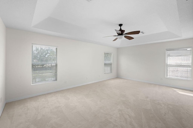 4429 67th St E, Bradenton, FL 34203 - spare room featuring a tray ceiling, healthy amount of natural light, and light carpet