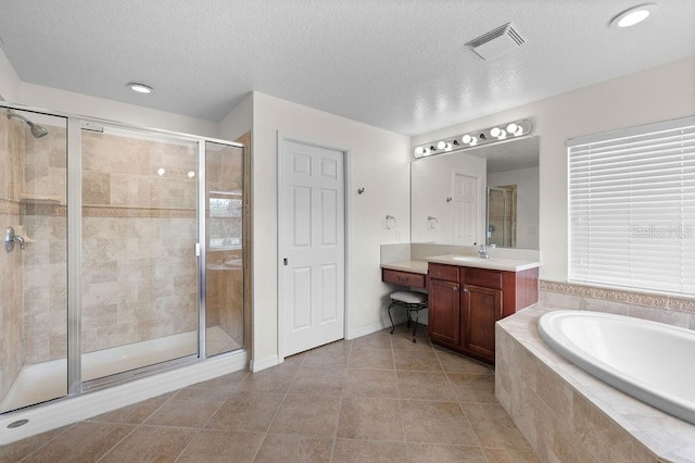 4429 67th St E, Bradenton, FL 34203 - bathroom featuring vanity, a garden tub, a stall shower, tile patterned floors, and a textured ceiling