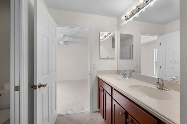 4429 67th St E, Bradenton, FL 34203 - bathroom with double vanity, tile patterned floors, a ceiling fan, and a textured ceiling