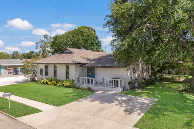 ranch-style home featuring a porch, stucco siding, a front lawn, and roof with shingles