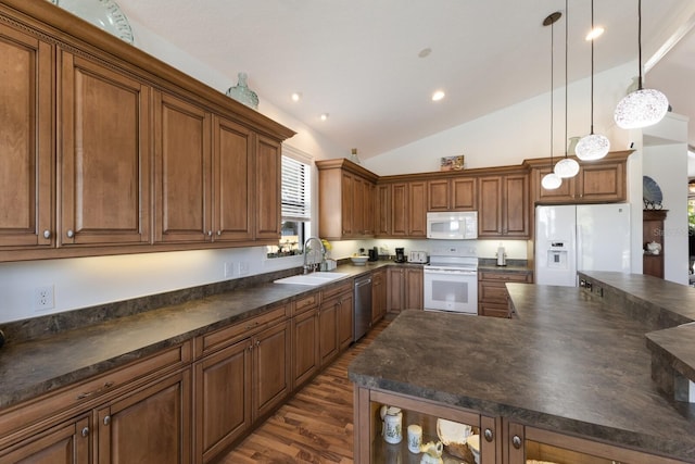 kitchen featuring white appliances, a sink, dark countertops, dark wood-style floors, and brown cabinetry