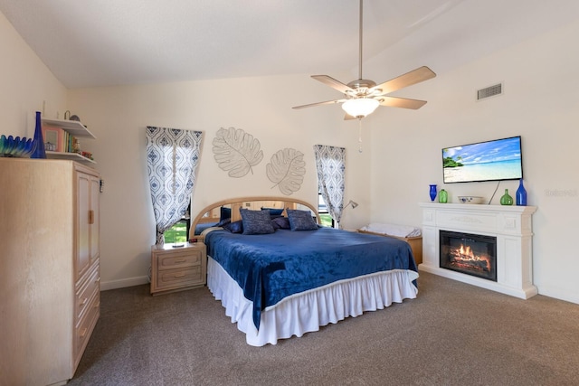 carpeted bedroom with lofted ceiling, a glass covered fireplace, ceiling fan, and baseboards