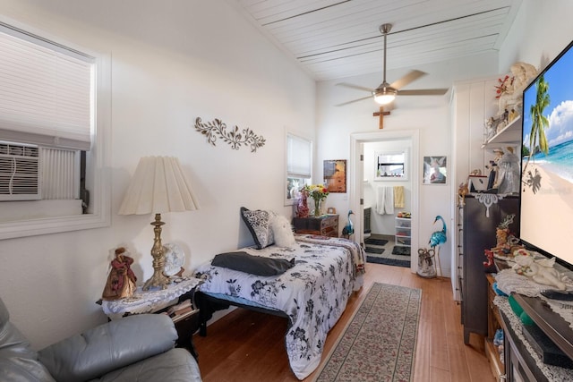 bedroom with light wood-type flooring, cooling unit, and a ceiling fan
