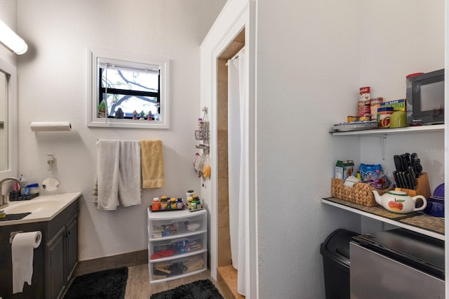 bathroom featuring a shower with shower curtain, vanity, and wood finished floors