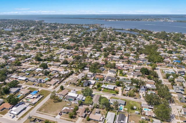 aerial view of property and surrounding area featuring a nearby body of water and nearby suburban area