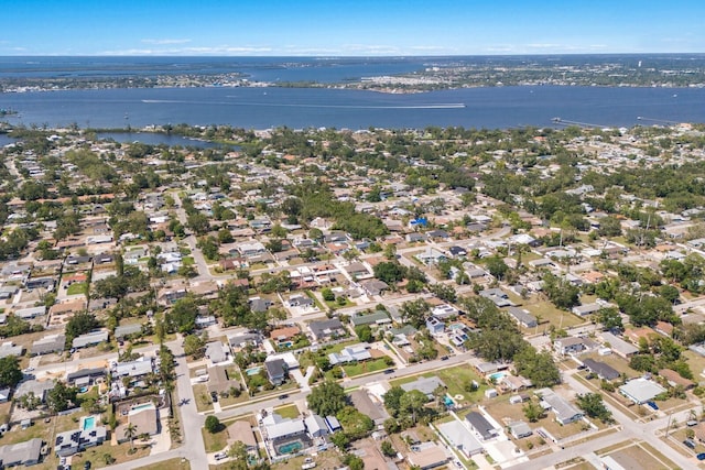 aerial view of property's location with a large body of water and nearby suburban area