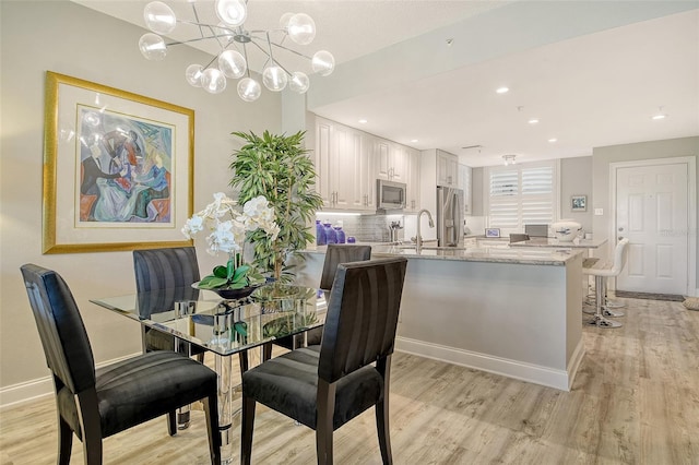 8735 Olde Hickory Ave Unit 8205, Sarasota, FL 34238 - dining space featuring light wood finished floors, a chandelier, and baseboards