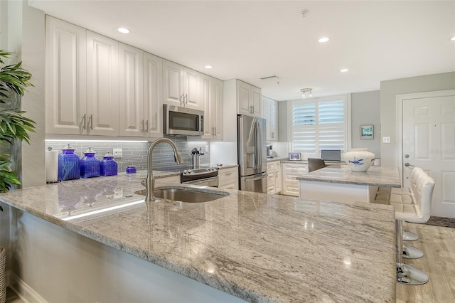8735 Olde Hickory Ave Unit 8205, Sarasota, FL 34238 - kitchen featuring stainless steel appliances, light stone countertops, tasteful backsplash, a sink, and recessed lighting