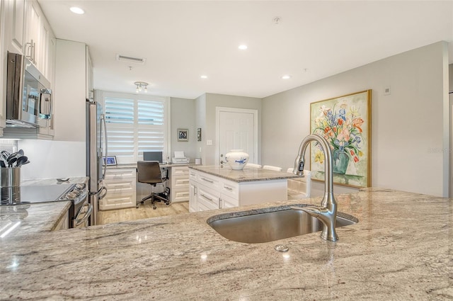 8735 Olde Hickory Ave Unit 8205, Sarasota, FL 34238 - kitchen with appliances with stainless steel finishes, a sink, an office area, light stone counters, and white cabinets