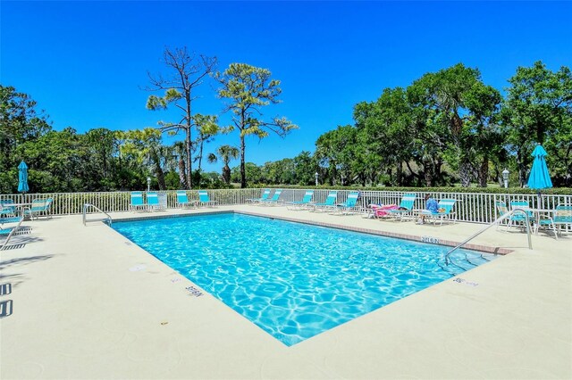 8735 Olde Hickory Ave Unit 8205, Sarasota, FL 34238 - community pool featuring fence, a patio area, and view of scattered trees