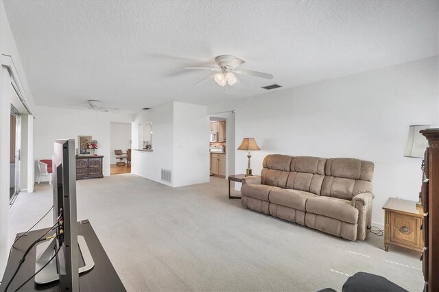 6701 12th Ave W, Bradenton, FL 34209 - living room featuring ceiling fan, light carpet, and a textured ceiling