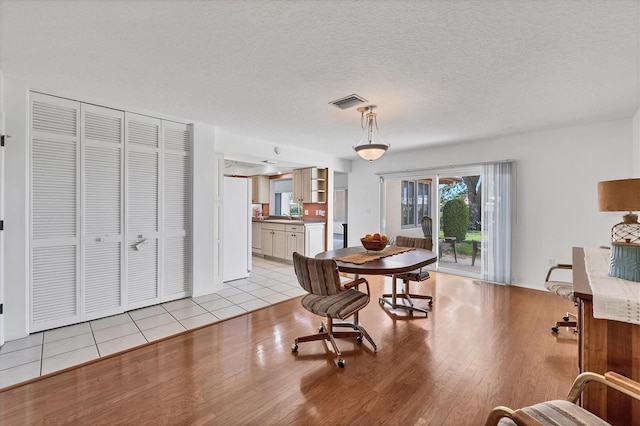 6701 12th Ave W, Bradenton, FL 34209 - dining room featuring light wood-style flooring and a textured ceiling