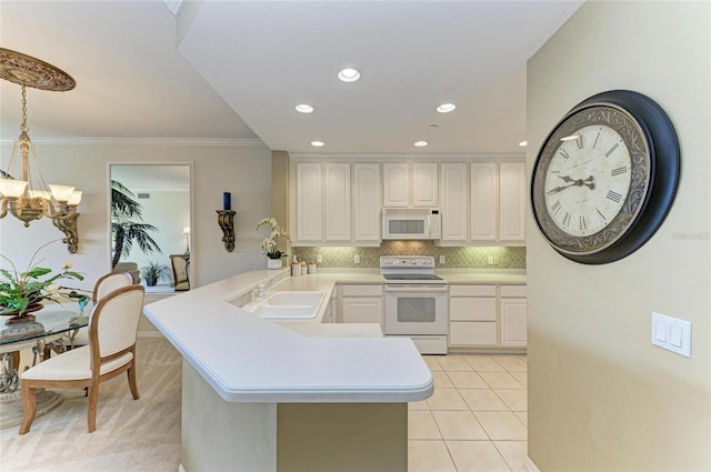 8422 Wethersfield Run Unit 103, Lakewood Ranch, FL 34202 - kitchen with white appliances, a chandelier, light countertops, a peninsula, and a sink