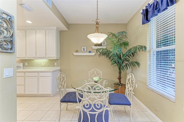 8422 Wethersfield Run Unit 103, Lakewood Ranch, FL 34202 - dining area featuring light tile patterned flooring, plenty of natural light, and baseboards