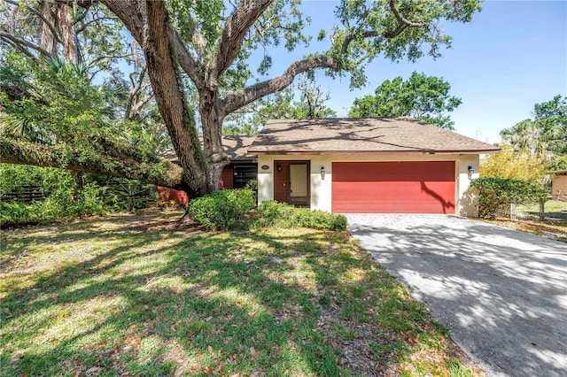 3934 Brookside Dr, Sarasota, FL 34231 - view of front of home with an attached garage, driveway, a front lawn, stucco siding, and a shingled roof