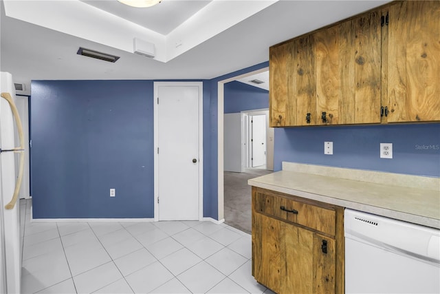 3934 Brookside Dr, Sarasota, FL 34231 - kitchen featuring white appliances, light countertops, baseboards, brown cabinets, and light tile patterned flooring