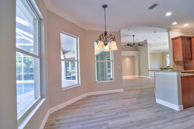 2809 112th Ter E, Parrish, FL 34219 - kitchen with crown molding, brown cabinetry, a chandelier, hanging light fixtures, and light wood-style floors