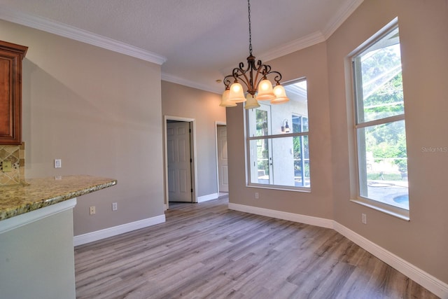 2809 112th Ter E, Parrish, FL 34219 - unfurnished dining area featuring light wood-style floors, a chandelier, healthy amount of natural light, and ornamental molding