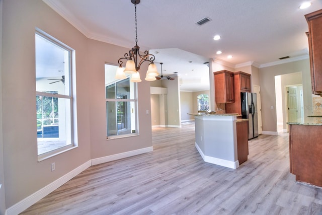 2809 112th Ter E, Parrish, FL 34219 - kitchen with stainless steel refrigerator with ice dispenser, open floor plan, crown molding, decorative light fixtures, and light wood-style floors