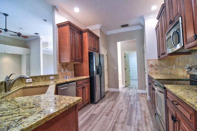 2809 112th Ter E, Parrish, FL 34219 - kitchen featuring stainless steel appliances, a sink, light stone countertops, ceiling fan, and backsplash
