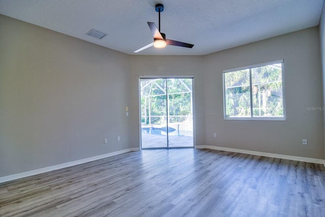 2809 112th Ter E, Parrish, FL 34219 - spare room featuring plenty of natural light, wood finished floors, baseboards, and a ceiling fan