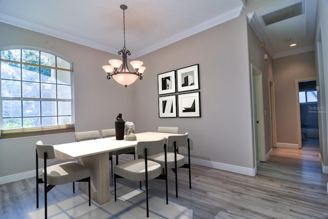 2809 112th Ter E, Parrish, FL 34219 - dining area featuring light wood finished floors, ornamental molding, and a chandelier