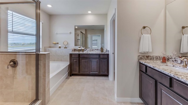 bathroom with a stall shower, a garden tub, two vanities, tile patterned flooring, and recessed lighting