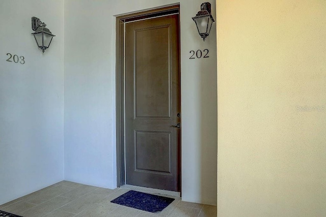 doorway to property featuring stucco siding
