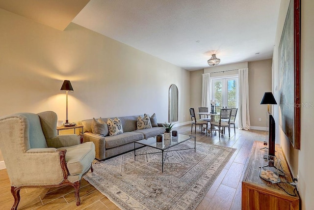 living area with light wood-type flooring and baseboards