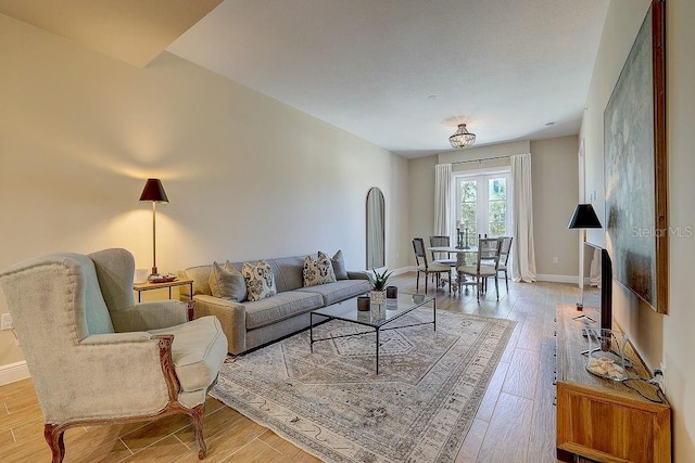 living area with light wood-type flooring and baseboards