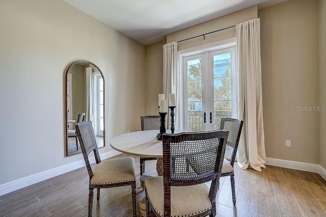 dining room with french doors, baseboards, and wood finished floors