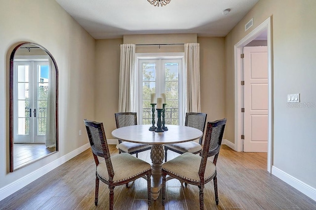 dining area with baseboards and light wood-style flooring