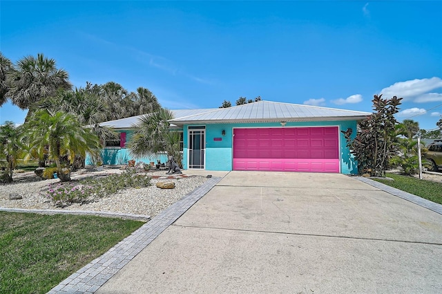 2127 Corfell St, Port Charlotte, FL 33948 - view of front of house featuring driveway, an attached garage, metal roof, and stucco siding
