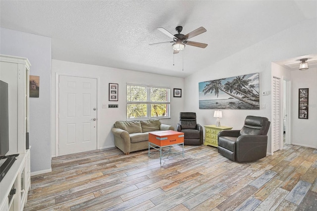2127 Corfell St, Port Charlotte, FL 33948 - living room with light wood-style flooring, ceiling fan, lofted ceiling, a textured ceiling, and baseboards