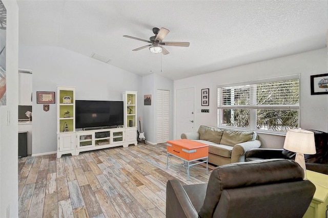 2127 Corfell St, Port Charlotte, FL 33948 - living area with wood finished floors, ceiling fan, vaulted ceiling, baseboards, and a textured ceiling