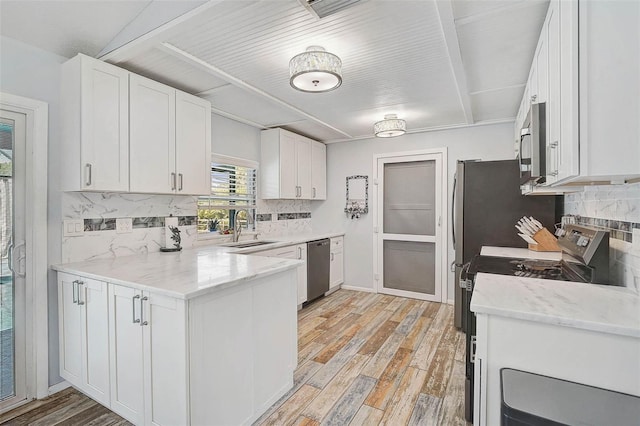 2127 Corfell St, Port Charlotte, FL 33948 - kitchen with a sink, white cabinets, appliances with stainless steel finishes, light wood-style flooring, and decorative backsplash