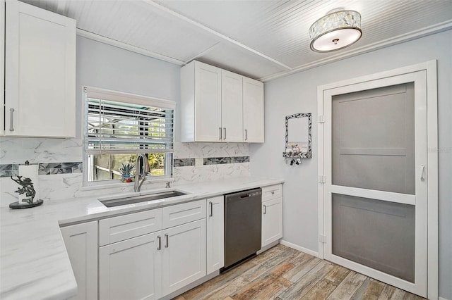 2127 Corfell St, Port Charlotte, FL 33948 - kitchen with stainless steel dishwasher, a sink, white cabinetry, backsplash, and light wood-type flooring