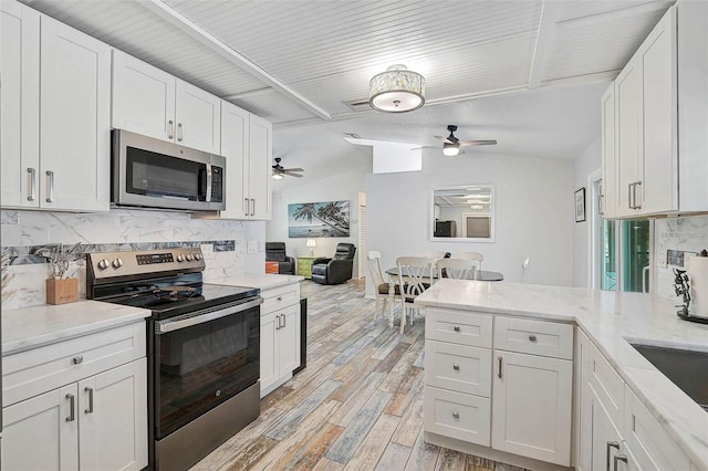 2127 Corfell St, Port Charlotte, FL 33948 - kitchen with appliances with stainless steel finishes, ceiling fan, tasteful backsplash, white cabinets, and light wood-style floors