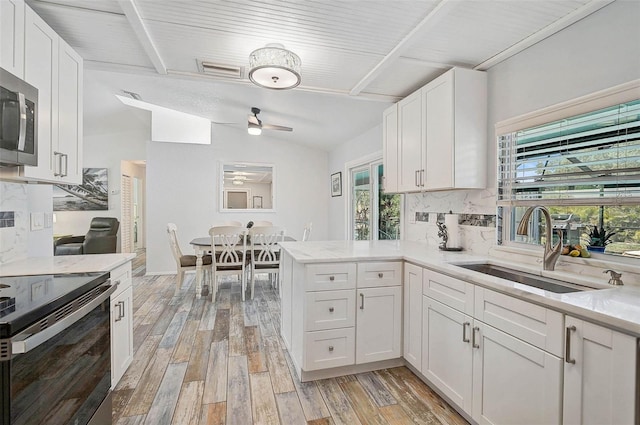 2127 Corfell St, Port Charlotte, FL 33948 - kitchen with a sink, electric range, light wood-style floors, and tasteful backsplash