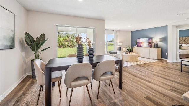 dining room with wood finished floors, baseboards, and recessed lighting