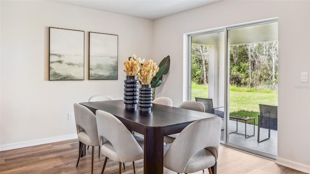 dining area with light wood-type flooring and baseboards