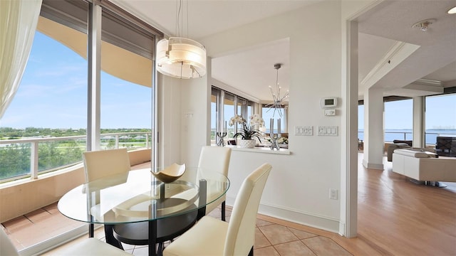 3060 Grand Bay Blvd Unit 182, Longboat Key, FL 34228 - dining area featuring baseboards, wood finished floors, and a chandelier