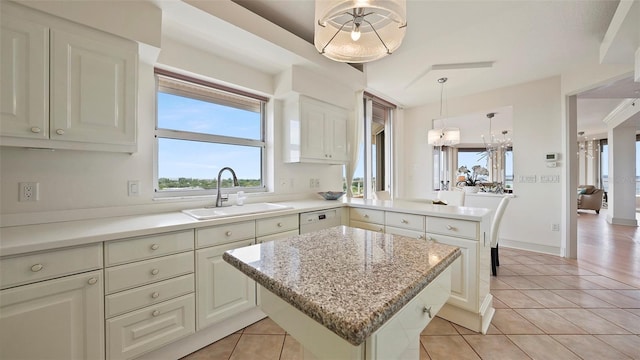 3060 Grand Bay Blvd Unit 182, Longboat Key, FL 34228 - kitchen with a sink, light tile patterned floors, a peninsula, and a center island