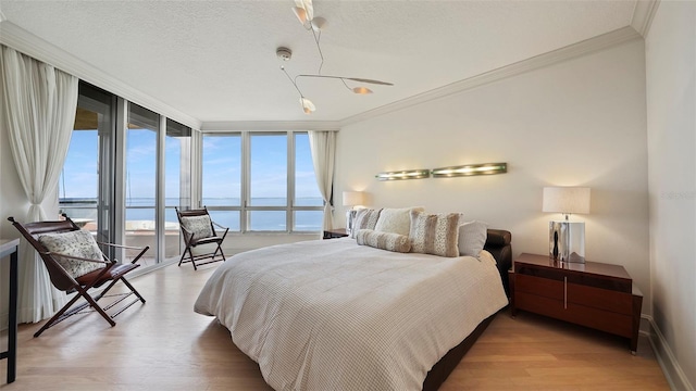 3060 Grand Bay Blvd Unit 182, Longboat Key, FL 34228 - bedroom with a water view, ornamental molding, wood finished floors, a wall of windows, and baseboards