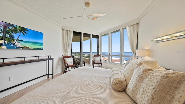 3060 Grand Bay Blvd Unit 182, Longboat Key, FL 34228 - bedroom featuring a water view, crown molding, access to exterior, wood finished floors, and baseboards